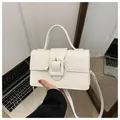 White faux leather rectangular handbag with large square buckle and top handle in matte finish - White