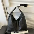 Minimalistische zwarte hobo-tas van kiezelleder met verstelbare schouderband en gesp - Zwart