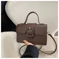 Deep coffee brown matte leather crossbody bag with a large decorative square buckle - Brown