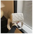 White quilted crossbody bag with stylish wide shoulder strap and gold hardware accents - White