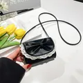 Sweet black mini crossbody bag featuring a large bow and white lace trim details - Black