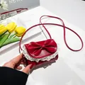 Mini red crossbody bag with a large bow, white lace trim, and thin shoulder strap - Red