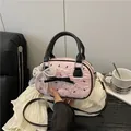 Bolso plisado rosa con estampados de lazos negros y colgante de encaje bandolera - Con Colgante de Lazo de Encaje y Perlas / Rosa Con Colgante