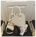 Detail of cream woven shell bag with silver zippers and FASHION & BAGS text on surface - Beige