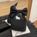 Elegante borsa a mano in tela nera con grande fiocco e tracolla a catena - Nero