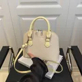 Elegante borsa beige intrecciata a conchiglia con tracolle gialle e scritte - Giallo