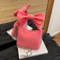 Bolso rosa vibrante con diseño de lazo, cadena plateada y cremallera - Rosa