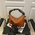Pleated leather handbag in tan and dark brown with gold hardware and crossbody strap - Brown