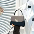 Chic black and gray color-block handbag with golden geometric F-clasp and top handle - Black