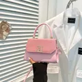 Pink leather handbag with woven texture flap and golden geometric buckle closure - Pink