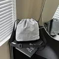 Lightweight grey nylon drawstring bucket bag with adjustable black strap on book - Gray