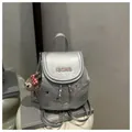 Detail of silver metallic backpack with IBCMB embroidery, fine chains and plush charm - Silver with Charm