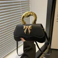 Borsa a tracolla nera a onde con chiusura a fiocco dorata e manico in metallo artistico - Nero