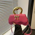 Borsa a tracolla rosa shocking con manico in oro fuso e base ondulata di design - Rosa