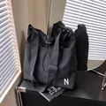 Borsa a tracolla minimalista in nylon nero con ricamo lettera N e chiusura a coulisse - Nero