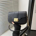 Chic black crocodile pattern handbag featuring a gold buckle and chain handle strap - Black