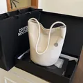 Sac seau chic en cuir souple blanc crème avec breloque argentée et texture grainée - Blanc
