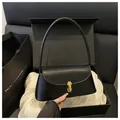 Bolso baguette negro con hebilla metálica dorada en una caja de regalo de lujo chic - Negro