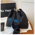 Black canvas tote bag with blue script lettering and adjustable strap for women - Black
