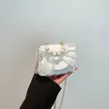 Mini white crossbody bag with tulle bow and pearl handle shown in hand, elegant design - White