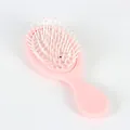 Détail de mini brosse rose montrant les picots de massage et le manche ergonomique - Rose Bébé Mat