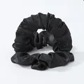 Detail eines schwarzen Satin-Haargummis mit glänzender Textur und plissiertem Design - Schwarz