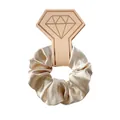 Close-up of champagne gold satin scrunchie on a diamond-shaped card for hair accessories - Champagne