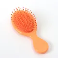 Mini-Haarbürste in Pfirsichfarben mit roten Borsten für die Kopfhautmassage - Glänzend Süßes Orange