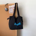 Black casual tote bag with blue Beach text and drawstring closure for daily use - Black