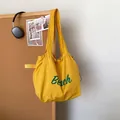 Bright yellow casual canvas tote bag with green Beach lettering and long handles - Yellow
