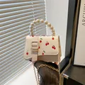 Mini sac crème à imprimé cerise avec poignée en perles et bandoulière dorée - Blanc