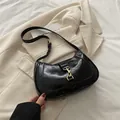 Bolso baguette de charol negro brillante con cierre dorado y correa ajustable de hombro - Negro