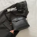Borsa a tracolla nera con trama intrecciata, dettagli dorati e tracolla larga - Nero