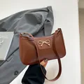 Bruine schoudertas van kunstleer met gouden strikgesp en elegant halfrond ontwerp voor dames - Bruin