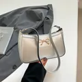 Zilveren schoudertas met gouden strik en metallic afwerking voor dames - Zilver