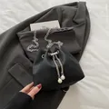 Bolso saco negro con cordón y cadena plateada con perlas decorativas en tela rugosa - Negro
