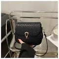 Dettaglio borsa a tracolla nera intrecciata con chiusura a ferro di cavallo in metallo oro - Nero