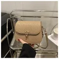 Dettaglio borsa a tracolla beige intrecciata con chiusura a goccia dorata - Kaki