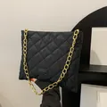 Fashionable black quilted nylon tote bag with bold gold chain strap and chic design - Black