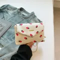 White corduroy crossbody bag with red strawberry print and gold chain strap detail - Strawberry Print White