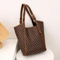 Braune Beuteltasche mit geometrischem Muster und Lederriemen auf weißem Sockel - Brauner Rhombus