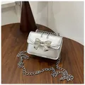 Mini silver metallic chain bag featuring a decorative bow and square flap design - Silver