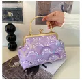 Close-up of purple sequin handbag featuring vintage gold floral handle and metal frame - Purple