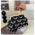 Detail of a black sequin evening bag with gold metal frame and round ring handle - Black