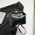 Borsa a secchiello nera con cuciture geometriche e rifiniture in metallo dorato - Nero