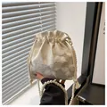 Detail of cream drawstring bucket bag featuring floral textures and pearl beaded strap - White