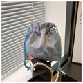 Detail view of light blue bucket bag with 3D butterfly appliques and pearl strap - Blue