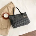 Black tote bag with repeating M geometric prints and a gold M pendant for commuting - Black