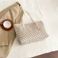Large beige tote bag with M-letter print and golden metal charm on white bedding - White