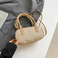 Minimalist beige canvas and brown leather pillow bag with woven texture and metal logo - Khaki